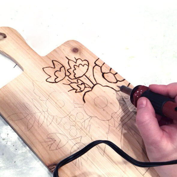 Wood-burning designs onto a cutting board