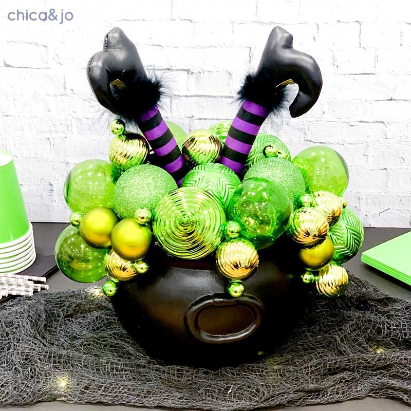 Green and gold ornament cauldron with purple-striped witch legs
