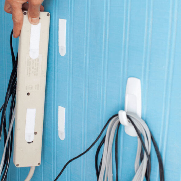 organize tv cords by hanging them on the back of furniture