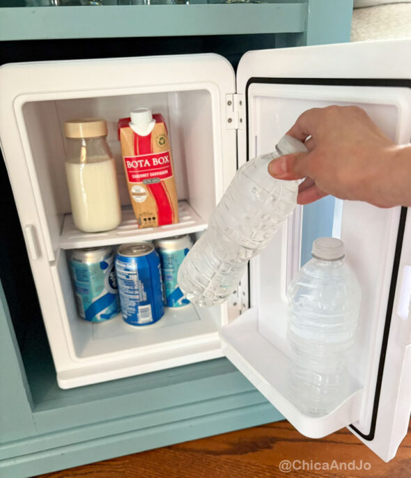 guest room essentials in a thrifted cabinet for amenities - mini fridge